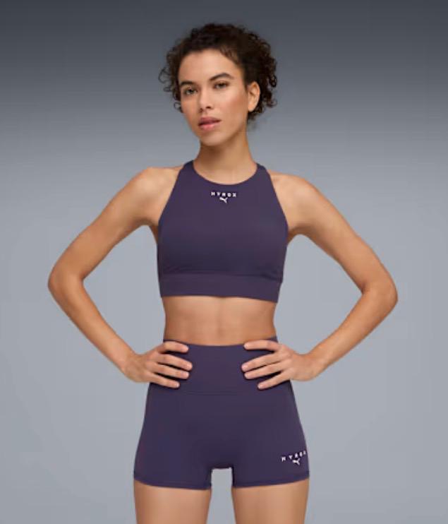 De Puma HYROX Shapeluxe sportbeha en korte legging afgebeeld in de kleur deep plum
